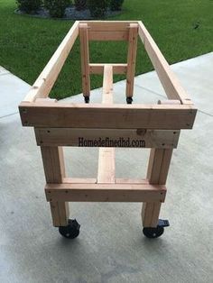 a wooden cart sitting on top of a cement floor next to a grass covered yard