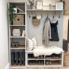 an image of a closet with shoes and coats on it's shelves in front of a door