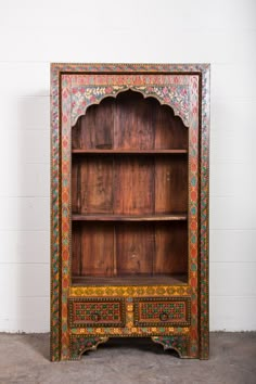 an ornate wooden bookcase with painted details