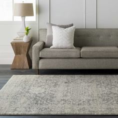 a living room with a couch, lamp and rug