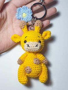 a crocheted giraffe keychain with a flower on it