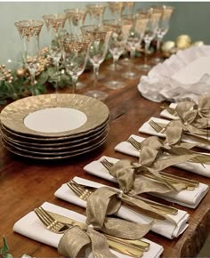 the table is set with gold and white plates, silverware, and napkins