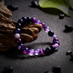 Product Description: The beads in a chakra bracelet can be made of many materials, but the colours are very important. Each of the chakras are represented by a colour - violet/white, indigo, light blues, green/pinks, yellows, orange and reds. The essential feature of a chakra bracelet is that the wearer understands its significance. Lava stone is porous and allows you to easily add a drop or two of your favorite essential oil. It is really easy to change up the scent because it wears off after a Spiritual Purple Crystal Bracelet With Round Beads, Purple Gemstone Beaded Bracelets For Meditation, Purple Bracelets With 8mm Beads For Healing, Purple Agate Gemstone Beads Bracelets, Purple Agate Bracelets With Gemstone Beads, Purple Agate Gemstone Beads Bracelet, Purple Agate Bracelet With Gemstone Beads, Purple Beaded Bracelets For Meditation, Purple Round Beaded Bracelets For Meditation