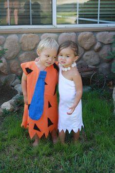 two children dressed up in costumes standing next to each other