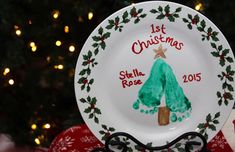 a white plate with a green christmas tree on it sitting in front of a christmas tree