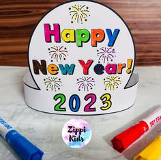 a happy new year's card with markers and crayons on the table