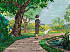 the woman is walking her dog down the path in the park with trees and water