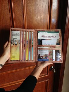 a person is opening up a wooden box with several books in it on the door