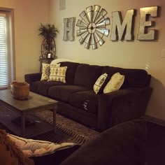 a living room filled with furniture and a large clock mounted to the wall above it