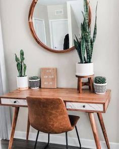 a wooden desk with a mirror and potted plants