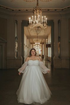 a woman in a white wedding dress posing for the camera