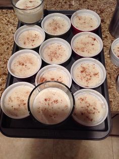 there are many cups with drinks in them sitting on the stove top, ready to be cooked