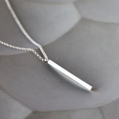 Perfectly straightforward and striking: a solid bar of sterling silver with an integrated loop hangs from a versatile box chain for a geometric statement of simplicity. The silver bar measures 1 3/4 inches long and is 2mm wide (squared). The necklace is finished with a simple silver lobster clasp. Choose your ideal chain length from the drop-down menu, and remember to factor in the length of the pendant to find your perfect necklace (chain length + pendant length). Elegant Silver Rectangular Bar Necklace, Modern Sterling Silver Bar Necklace, Classic Silver Bar Necklace As A Gift, Silver Minimalist Necklace With Rectangular Pendant, Classic Sterling Silver Bar Necklace, Simple Silver Rectangular Pendant Jewelry, Minimalist Silver Rectangular Pendant Jewelry, Modern Sterling Silver Bar Necklace For Gift, Modern Sterling Silver Bar Necklace As Gift