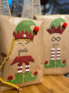 two bags with christmas decorations on them sitting on a wooden table next to each other