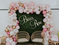 a floral backdrop with balloons and chairs for a bridal rose party