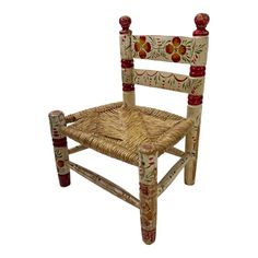 a wicker chair with red and green decorations on it's back legs, sitting against a white background