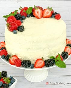 a white cake topped with berries and strawberries