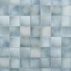 a blue tiled wall with white and gray squares