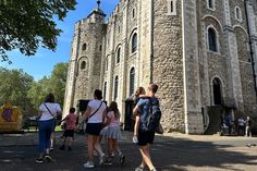 some people are standing in front of a castle