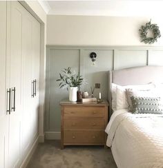 a white bed sitting next to a wooden dresser