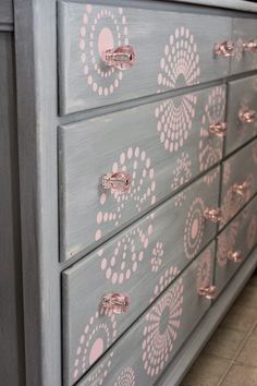 a gray dresser with pink flowers painted on the drawers and knobs, in a kitchen