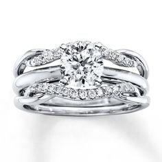 a white gold engagement ring set with an oval diamond center and two rows of diamonds on each band