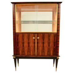 an antique display cabinet with glass doors and wood trimmings on the front, against a white background