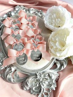 there is a silver plate with pink and white flowers on it, along with two roses