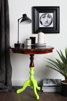 a table with a lamp and pictures on the wall