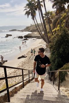 a man is walking up some stairs to the beach