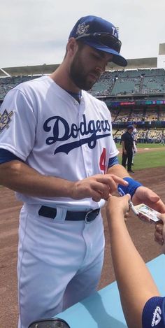 a dodgers baseball player signing autographs for fans