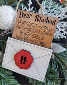 a christmas ornament hanging from a tree with an envelope and letter on it