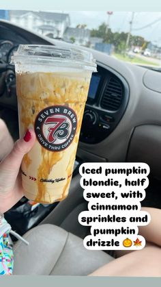 a woman holding up a cup of iced pumpkin blondie with cinnamon sprinkles and drizzle