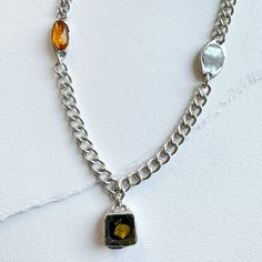 Amber, Mother of Pearl, and Carved Resin charm handset in Solid Silver. One-of-a-kind 16" chain The necklace has a molten silver one-of-a-kind setting that is expertly cast from high-quality solid silver in NYC. The heavy-weight solid silver chain is made in Italy, ensuring both durability and timelessness. Wear it every day to express your individuality, and let it be a timeless symbol of the enduring beauty of nature and the personal connection it brings. Resin Charms, Mother Of Pearl, Silver Chain, High Quality, It Cast, Carving, Chain, Silver