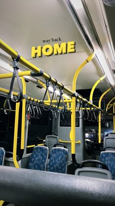 the inside of a bus with blue seats and yellow railings that read, way back home