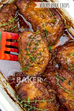 baked pork chops in a white casserole dish with garnishes