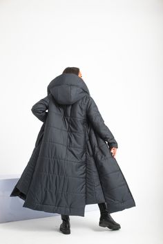 "Stay warm while staying fashionable with this unique cyberpunk puffer jacket with two side pockets, a large and cozy hood, and an extravagant asymmetrical design on both sides. The long double-sided zipper and the high collar will keep you comfy yet so stylish and chic. This maxi quilted coat has a street vibe and will keep you warm for sure. A good jacket or coat can really make an outfit. It's the finishing touch before walking out the door. The model in the picture is 170cm. ⅼ 5.7 ft. tall and is wearing size XS / Color: Dark gray 🌟 INFO: * Worldwide EXPRESS shipping - please provide a phone number for shipping documents * US Sizing XS to 4XL - size chart available below - all measurements of the body 🌟 MATERIAL & CARE * fabric: polyester, quilted fabric * hand wash * cold water 30 d Women Coats Winter, Plus Size Coats For Women Winter, Long Quilted Jacket, Quilted Jacket Women, Walking Out The Door, Asymmetrical Coat, Make An Outfit, Walking Out, Womens Quilted Jacket