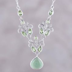 Verdant forests inspire stylish allure in this beautiful necklace designed by Shubhra Singh of India. Sterling silver leafy elements are adorned with dazzling peridot gems, making this perfect for an evening look. A single serpentine pendant dances below. Elegant Peridot Necklaces For Wedding, Elegant Peridot Jewelry With Natural Stones, Elegant Green Necklace With Gemstone Accents, Green Gemstone Sterling Silver Necklaces, Green Gemstone Accented Sterling Silver Necklace, Green Sterling Silver Necklaces With Gemstone Accents, Sterling Silver Heart Necklace, Rose Quartz Earrings, Silver Heart Necklace