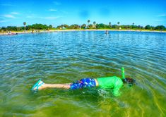 a person floating in the water with a green tube