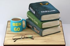 three books stacked on top of each other next to a cup of coffee and reading glasses