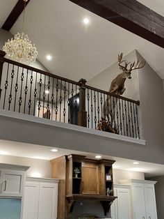 a deer head mounted to the top of a railing above a kitchen counter and sink