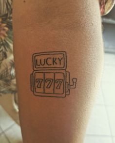 a woman's leg with a tattoo that reads lucky and has a gas pump on it