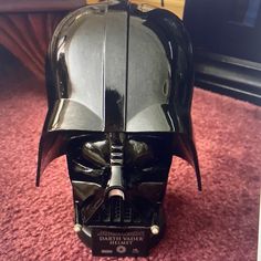 a darth vader helmet sitting on top of a red carpet