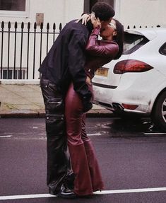 a man and woman kissing on the street