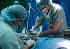 two doctors performing surgery in an operating room