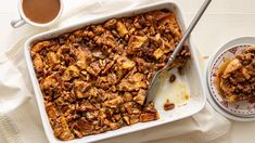 a casserole dish with bread pudding and two cups of coffee