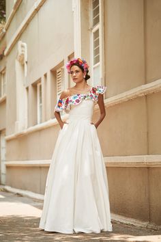 a woman in a white dress standing on the street