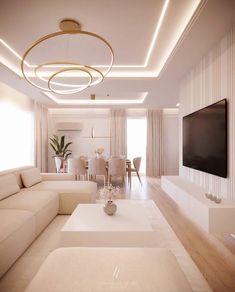 a living room filled with white furniture and a flat screen tv mounted on the wall