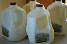 four gallon jugs of milk sitting on a counter