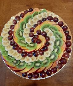 a platter filled with sliced up fruit on top of a wooden table